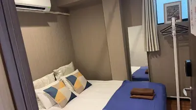 a small bedroom with a bed and a mirror at Sky \u6674\u7a7a\u5854 \u72ec\u7acb\u53cc\u4eba\u95f4 \u4f46\u662f\u5171\u7528\u6d74\u5ba4\u5395\u6240 in Tokyo
