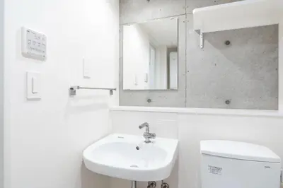 a white bathroom with a sink and a mirror at \u30eb\u30af\u30ec\u6771\u65b0\u5bbf in Tokyo