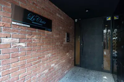a brick wall with a sign on the side of a building at \u30eb\u30af\u30ec\u6771\u65b0\u5bbf in Tokyo