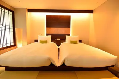 a bedroom with two beds with white sheets at Hotel Ryumeikan Ochanomizu Honten in Tokyo