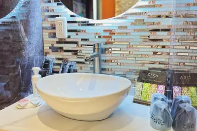 a bathroom with a bowl sink and books on a counter at Exquisite business hotel Bella in Tokyo