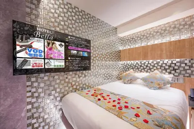 a bedroom with a bed and a tiled wall at Exquisite business hotel Bella in Tokyo