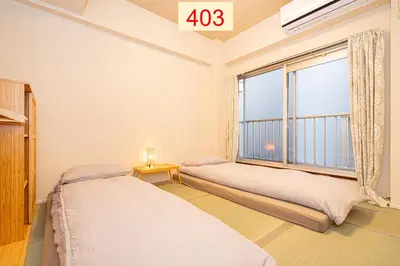 two beds in a room with a large window at Downtown Apartment/ SHIBUYA Station 10mins on foot in Tokyo