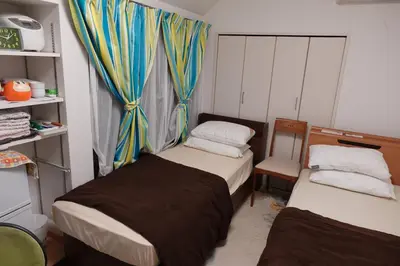 a small room with two beds and a window at WOMEN ONLY 3F in Tokyo