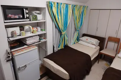 a small bedroom with a small bed and a tv at WOMEN ONLY 3F in Tokyo