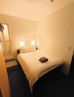 a bedroom with a bed with two towels on it at Oda hotel Akihabara in Tokyo