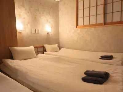 two beds in a room with towels on them at Oda hotel Akihabara in Tokyo