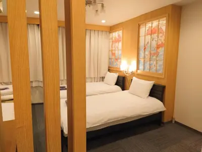 two beds in a small room with windows at Oda hotel Akihabara in Tokyo