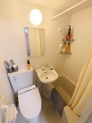 a white bathroom with a toilet and a sink at Oda hotel Akihabara in Tokyo