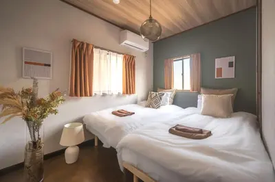 two beds in a hotel room with towels on them at Japandi House Haneda in Tokyo