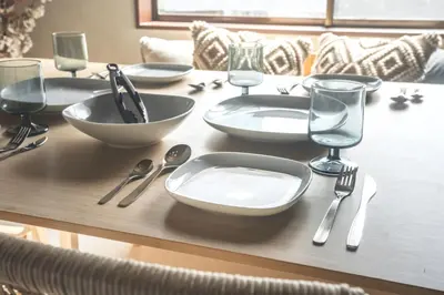 a wooden table with plates and utensils on it at Japandi House Haneda in Tokyo