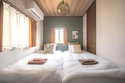 a room with two beds with towels on them at Japandi House Haneda in Tokyo