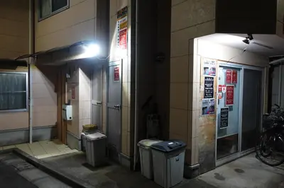 a building with two trash cans on the side of it at Sunny moe oo in Tokyo