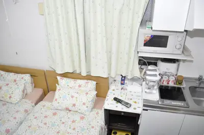 a small room with two beds and a microwave at Sunny moe oo in Tokyo