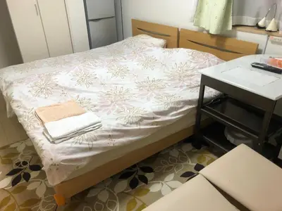a small bed in a room with a table at Sunny moe oo in Tokyo