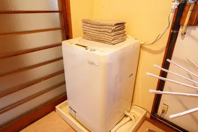 a stack of towels on top of a refrigerator at LARGE HOUSE Lodging Hidamari in Tokyo