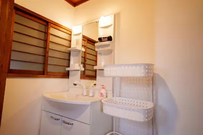 a bathroom with a sink and a mirror at LARGE HOUSE Lodging Hidamari in Tokyo