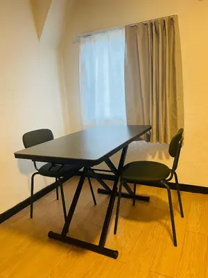 a table and two chairs in a room with a bed at home shinjuku west301 in Tokyo