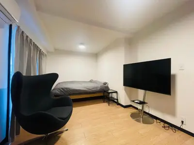a living room with a chair and a television at home shinjuku west301 in Tokyo