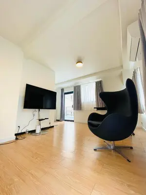 a living room with a black chair and a flat screen tv at home shinjuku west301 in Tokyo