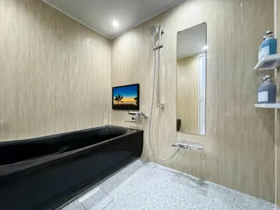 a bathroom with a black tub and a shower at Hotel BaliBali \u9daf\u8c37 in Tokyo