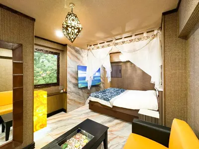 a bedroom with a bed and a chandelier at Hotel BaliBali \u9daf\u8c37 in Tokyo