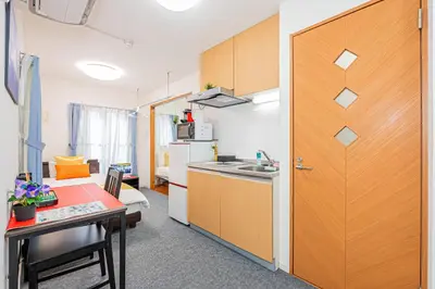 a kitchen with a table and a door to a room at KYARA HOTEL \u4e80\u6238a in Tokyo
