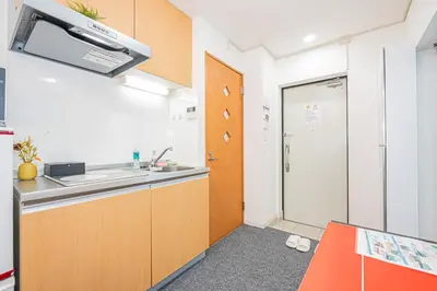 a small kitchen with a sink and a door at KYARA HOTEL \u4e80\u6238a in Tokyo