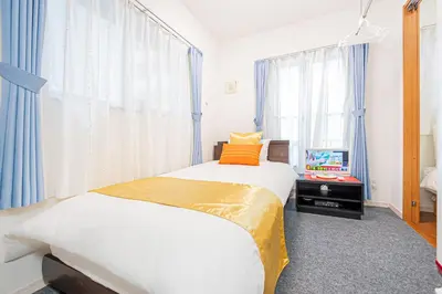 a bedroom with two beds and a tv in it at KYARA HOTEL \u4e80\u6238a in Tokyo