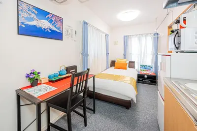 a small room with a bed and a desk and a kitchen at KYARA HOTEL \u4e80\u6238a in Tokyo