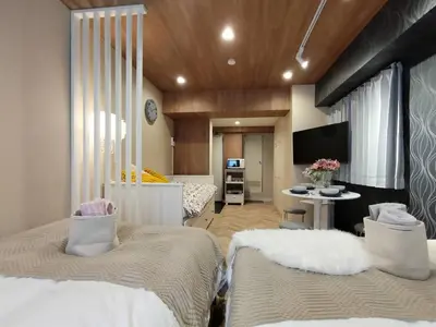 a bedroom with two beds and a tv in it at \u30b4\u30b8\u30e9\u30d8\u30c3\u30c9\u307e\u3067\u5f92\u6b699\u5206 \u6700\u5bc4\u308a\u99c5\u307e\u30674\u5206 \u30c0\u30d6\u30eb\u30d9\u30c3\u30c9\u6570\u53f0\u30d5\u30a1\u30df\u30ea\u30fc\u5411\u3051\u90e8\u5c4b in Tokyo