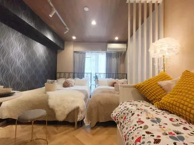 a bedroom with three beds and a table and a couch at \u30b4\u30b8\u30e9\u30d8\u30c3\u30c9\u307e\u3067\u5f92\u6b699\u5206 \u6700\u5bc4\u308a\u99c5\u307e\u30674\u5206 \u30c0\u30d6\u30eb\u30d9\u30c3\u30c9\u6570\u53f0\u30d5\u30a1\u30df\u30ea\u30fc\u5411\u3051\u90e8\u5c4b in Tokyo