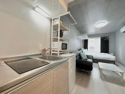 a kitchen with a sink and a living room with a bed at Hotel \u30de\u30fc\u30d9\u30e9\u30b9Asakusa #1 in Tokyo