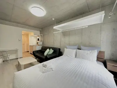 a bedroom with a large white bed and a couch at Hotel \u30de\u30fc\u30d9\u30e9\u30b9Asakusa #1 in Tokyo