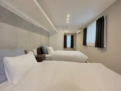 a white bedroom with two beds and a window at Hotel \u30de\u30fc\u30d9\u30e9\u30b9Asakusa#LOFT#2 in Tokyo