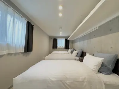 a bedroom with three beds with white sheets and a window at Hotel \u30de\u30fc\u30d9\u30e9\u30b9Asakusa#LOFT#2 in Tokyo
