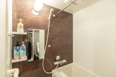 a bathroom with a shower and a sink and a mirror at Caesar House Connecting Room 201and202 in Tokyo