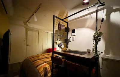 a bedroom with a bed and a desk and a lamp at Caesar House Connecting Room 201and202 in Tokyo