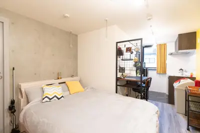 a bedroom with a white bed and a desk at Caesar House Connecting Room 201and202 in Tokyo