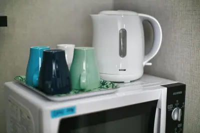 a white appliance with cups and a blender on top of a microwave at QU202 Edogawa Japanese Style Apartment 202 has direct access to Akihabara and Shinjuku, with convenient transportation and free WiFi in Tokyo