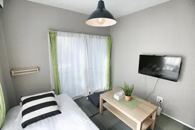 a bedroom with a bed and a tv and a table at QU202 Edogawa Japanese Style Apartment 202 has direct access to Akihabara and Shinjuku, with convenient transportation and free WiFi in Tokyo