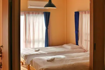 two beds in a room with a window at QU301 Edogawa Japanese Style Apartment 301 has direct access to Akihabara and Shinjuku, with convenient transportation and free WiFi in Tokyo