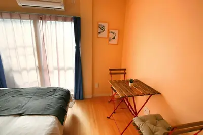 a bedroom with a bed and a table and a window at QU301 Edogawa Japanese Style Apartment 301 has direct access to Akihabara and Shinjuku, with convenient transportation and free WiFi in Tokyo