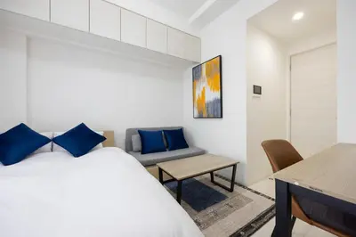 a bedroom with a bed and a table and a couch at \u30d7\u30ec\u30fc\u30eb\u30c9\u30a5\u30fc\u30af\u5927\u68ee\u753a ll in Tokyo