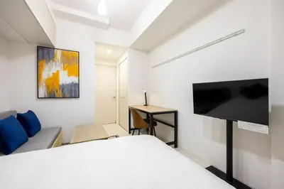 a bedroom with a bed and a flat screen tv at \u30d7\u30ec\u30fc\u30eb\u30c9\u30a5\u30fc\u30af\u5927\u68ee\u753a ll in Tokyo