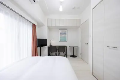 a bedroom with a white bed and a table at \u30d7\u30ec\u30fc\u30eb\u30c9\u30a5\u30fc\u30af\u5927\u68ee\u753a ll in Tokyo