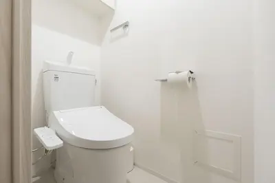 a white bathroom with a toilet and a roll of toilet paper at \u30d7\u30ec\u30fc\u30eb\u30c9\u30a5\u30fc\u30af\u5927\u68ee\u753a ll in Tokyo