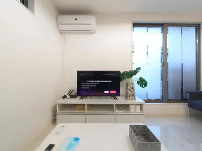 a living room with a flat screen tv on a table at New building Shinjuku area town house in Tokyo