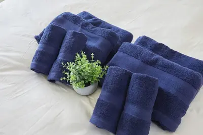 three blue towels and a potted plant on a bed at Sun white Gyoutoku 301 in Tokyo