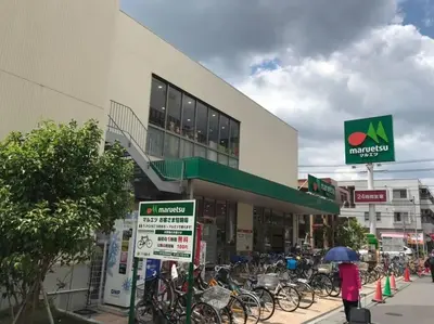 a woman with an umbrella standing in front of a store at Sun white Gyoutoku 301 in Tokyo